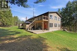 Back of property with a yard, a patio, and a wooden deck - 