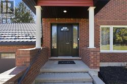 Entrance to property featuring covered porch and brick siding - 