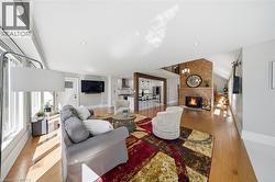 Living area with a fireplace, light wood-style flooring, and recessed lighting - 