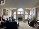 Living area featuring vaulted ceilings, a central fireplace with a mantel, and decorative arched windows - 350 Havendale Crescent, Waterloo, ON  - Indoor Photo Showing Living Room With Fireplace 