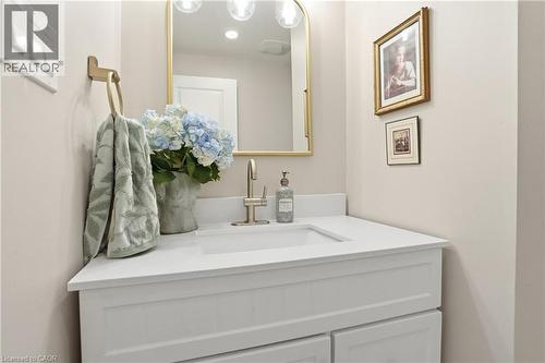 White vanity with shaker-style cabinetry, an integrated sink, and a light-toned countertop - 47 New Street, Hamilton, ON - Indoor Photo Showing Bathroom