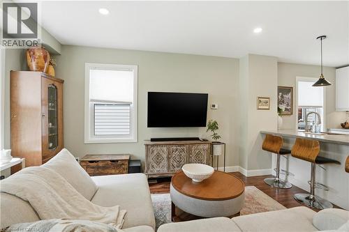 Open-concept living area featuring rich wood-finish flooring, recessed ceiling lighting, and a neutral wall palette - 47 New Street, Hamilton, ON - Indoor Photo Showing Living Room