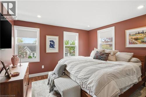 Spacious bedroom featuring warm-toned walls, recessed lighting, and multiple windows with white trim - 47 New Street, Hamilton, ON - Indoor Photo Showing Bedroom