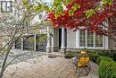 Exterior featuring a stone and siding facade, an intricate paver patio, a two-car garage with modern doors, and mature landscaping - 4285 Couples Crescent, Burlington, ON  - Outdoor 