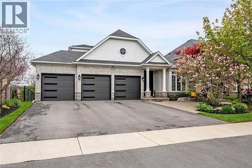 Light brick exterior with white siding accents and a covered entryway - 4285 Couples Crescent, Burlington, ON - Outdoor With Facade