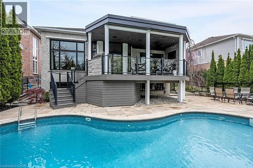 Curved-edge swimming pool with surrounding stone patio - 4285 Couples Crescent, Burlington, ON - Outdoor With In Ground Pool With Deck Patio Veranda