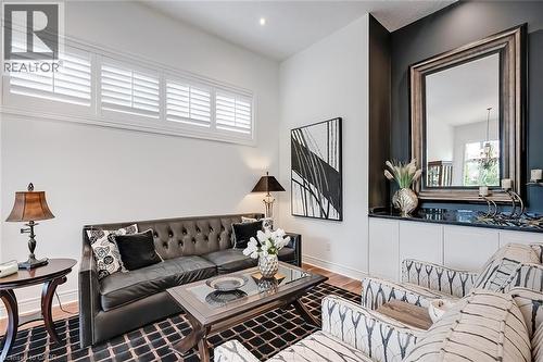 Living area featuring wood-finish flooring and a distinctive dark accent wall - 4285 Couples Crescent, Burlington, ON - Indoor Photo Showing Other Room