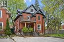 Brick exterior with a metal roof accent, second-story balcony with metal railings, and a ground-level covered porch - 15 Gordon Avenue, Kitchener, ON  - Outdoor 