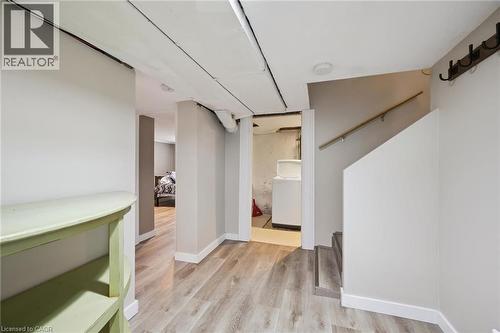 Finished lower level with wood-finish flooring, light-toned walls, recessed lighting, and a partial staircase featuring a wood handrail - 15 Gordon Avenue, Kitchener, ON - Indoor Photo Showing Other Room