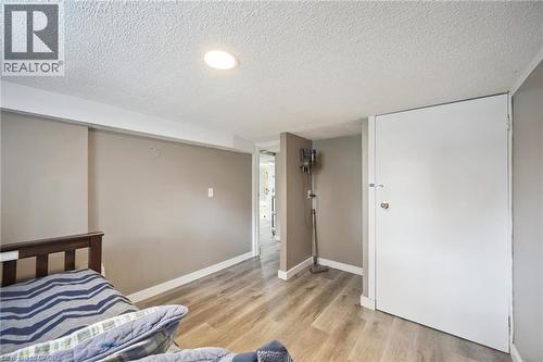 Recessed lighting illuminates this room featuring wood-finish flooring, neutral wall tones, and white trim - 15 Gordon Avenue, Kitchener, ON - Indoor Photo Showing Bedroom