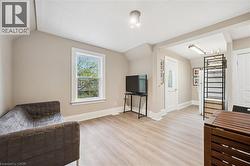 Open-concept living space featuring wood-finish flooring, neutral wall tones, and white trim - 