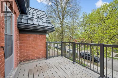Balcony featuring wood-finish decking and dark metal railings - 15 Gordon Avenue, Kitchener, ON - Outdoor With Exterior