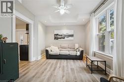 Living area with wood-finish flooring, recessed lighting, and a ceiling fan - 