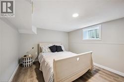 Inviting room featuring wood-finish flooring, recessed ceiling lighting, and a white-trimmed window - 