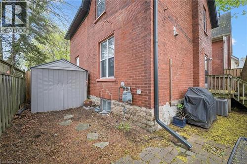 Brick exterior featuring a stone foundation and multiple windows - 15 Gordon Avenue, Kitchener, ON - Outdoor With Exterior