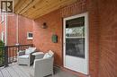 Front porch featuring a durable composite deck, black metal railing, and a wood-paneled ceiling - 15 Gordon Avenue, Kitchener, ON  - Outdoor With Deck Patio Veranda With Exterior 