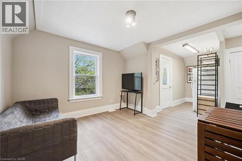 Open-concept living space featuring wood-finish flooring, neutral wall tones, and white trim - 15 Gordon Avenue, Kitchener, ON - Indoor