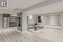 Spacious living area featuring light wood-finish flooring and recessed lighting - 