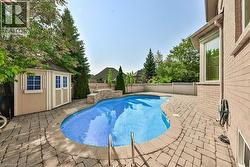 Freeform swimming pool with stone coping and blue mosaic tile interior - 