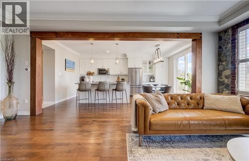 Open-concept living area featuring rich wood-finish flooring, exposed wood beams, and a stone accent wall - 19 Shoreacres Drive, Kitchener, ON - Indoor Photo Showing Living Room