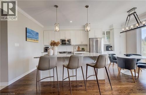 Gourmet kitchen with white cabinetry, stainless steel appliances, speckled stone countertops, a subway tile backsplash, and dark wood-finish flooring - 19 Shoreacres Drive, Kitchener, ON - Indoor Photo Showing Kitchen With Stainless Steel Kitchen With Upgraded Kitchen
