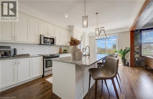 Kitchen island with a granite-style countertop and pendant lighting - 19 Shoreacres Drive, Kitchener, ON - Indoor Photo Showing Kitchen With Stainless Steel Kitchen With Upgraded Kitchen