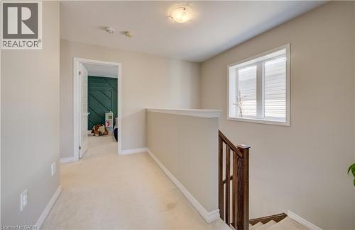 Upper-level hallway featuring a window with horizontal blinds, neutral wall paint, and carpeted flooring - 19 Shoreacres Drive, Kitchener, ON - Indoor Photo Showing Other Room