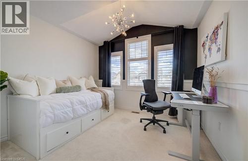 Bright room featuring white plantation shutters and black drapery, with a modern Sputnik-style chandelier - 19 Shoreacres Drive, Kitchener, ON - Indoor Photo Showing Bedroom