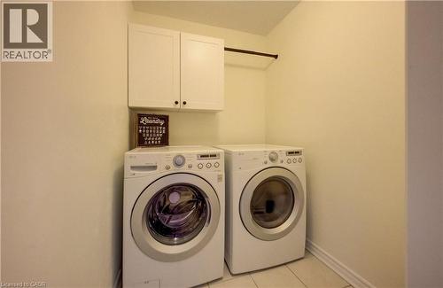 Dedicated laundry area featuring tile flooring, upper cabinetry, and a clothing rod - 19 Shoreacres Drive, Kitchener, ON - Indoor Photo Showing Laundry Room