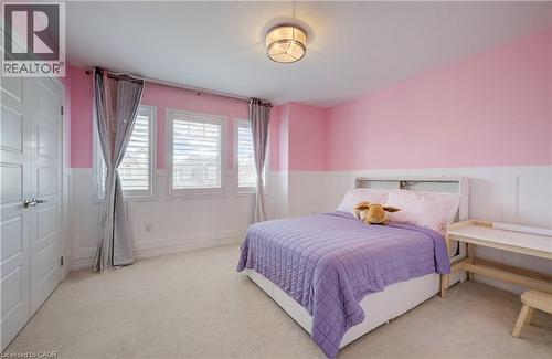 Interior room featuring soft carpet flooring, white wainscoting, and three windows with shutters - 19 Shoreacres Drive, Kitchener, ON - Indoor Photo Showing Bedroom