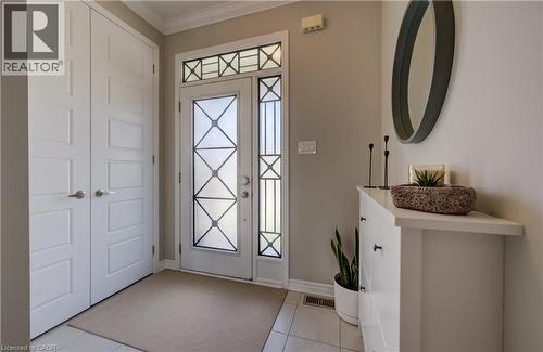 Entryway featuring tiled flooring, a decorative glass front door with sidelight and transom, and a built-in storage cabinet - 19 Shoreacres Drive, Kitchener, ON - Indoor Photo Showing Other Room
