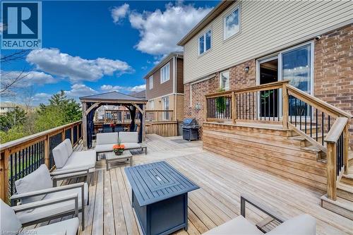 Multi-level wood deck featuring a covered gazebo, staircase with wood railings, and a sliding glass door entry to the home's brick and siding exterior - 19 Shoreacres Drive, Kitchener, ON - Outdoor With Deck Patio Veranda With Exterior