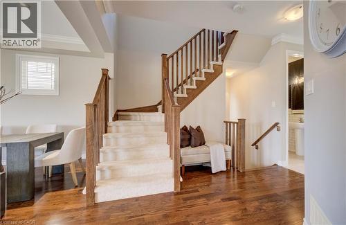 Hardwood-finish flooring extending through the entry, with a carpeted staircase featuring wood newel posts and railings - 19 Shoreacres Drive, Kitchener, ON - Indoor Photo Showing Other Room