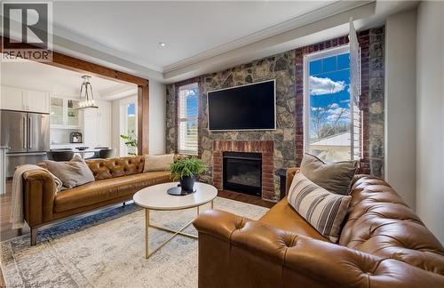 Living area featuring a stone and brick fireplace surround, wood-finish flooring, and crown molding - 19 Shoreacres Drive, Kitchener, ON - Indoor Photo Showing Living Room With Fireplace