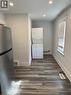 Clothes washing area featuring stacked washer / dryer and dark wood-type flooring - 1090 Cannon Street E, Hamilton, ON  - Indoor 