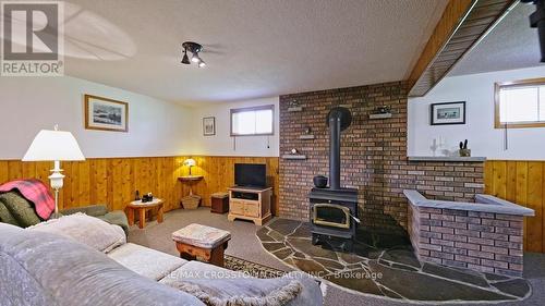 Family room with woodstove - 50 Withall Grove, Tiny, ON - Indoor With Fireplace