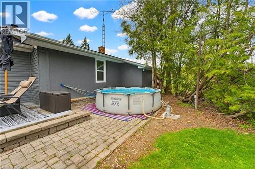 Hardscaped patio area featuring interlock and a small above ground pool - 10 Huisman Lane, Hamilton, ON - Outdoor With Above Ground Pool With Exterior