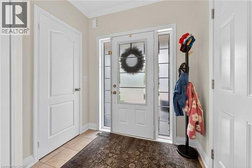 Entryway featuring a white paneled door with side lights, ceramic tile flooring, and crown molding - 4236 Prudham Avenue, Burlington, ON - Indoor Photo Showing Other Room