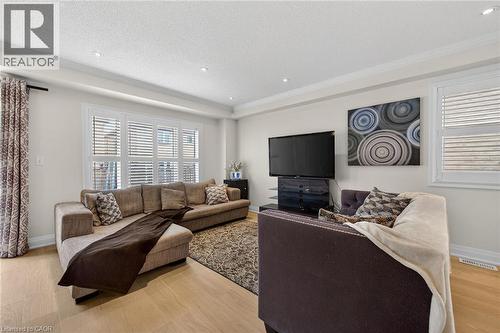 Bright living area featuring wood-finish flooring, recessed lighting, and crown molding - 4236 Prudham Avenue, Burlington, ON - Indoor Photo Showing Living Room