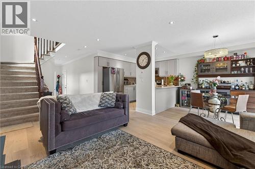 Open-concept living area featuring light wood-finish flooring, recessed lighting, crown molding, and a built-in kitchen island with a breakfast bar - 4236 Prudham Avenue, Burlington, ON - Indoor Photo Showing Living Room