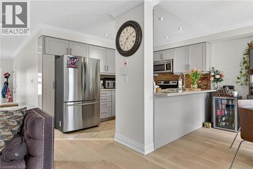 Kitchen featuring light gray cabinetry with brushed nickel hardware, stainless steel appliances, and a brick-patterned backsplash - 4236 Prudham Avenue, Burlington, ON - Indoor Photo Showing Kitchen