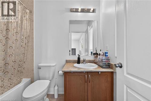 Bathroom featuring a single vanity with wood-finish cabinetry, a light-colored countertop, and a rectangular mirror - 4236 Prudham Avenue, Burlington, ON - Indoor Photo Showing Bathroom