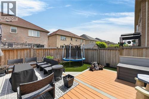 Multi-level backyard featuring a wood-finish deck and artificial turf - 4236 Prudham Avenue, Burlington, ON - Outdoor With Deck Patio Veranda With Exterior