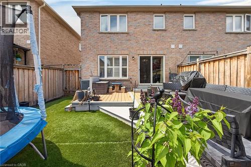 Private backyard featuring a multi-level composite deck, artificial turf, and a wood privacy fence - 4236 Prudham Avenue, Burlington, ON - Outdoor With Deck Patio Veranda With Exterior