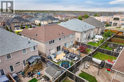 Fenced backyard with a multi-level deck, mature trees, and a ground-level patio - 4236 Prudham Avenue, Burlington, ON - Outdoor