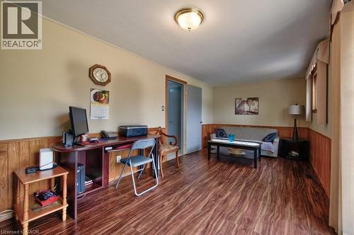 Versatile interior space featuring wood-finish flooring, wood paneling, light-toned walls, and a ceiling-mounted light fixture - 34 Westwood Crescent, Kitchener, ON - Indoor