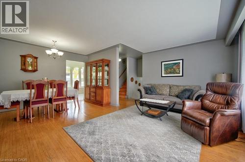 Open concept living and dining area featuring wood-finish flooring, neutral grey walls, and white trim - 34 Westwood Crescent, Kitchener, ON - Indoor Photo Showing Living Room