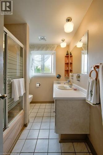 Full bathroom featuring a shower-tub combination with sliding glass doors, a vanity with an integrated sink and countertop, and tile flooring - 34 Westwood Crescent, Kitchener, ON - Indoor Photo Showing Bathroom