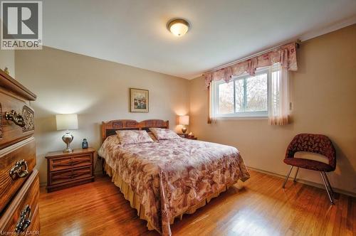 Hardwood flooring, neutral wall paint, and a white-framed window - 34 Westwood Crescent, Kitchener, ON - Indoor Photo Showing Bedroom