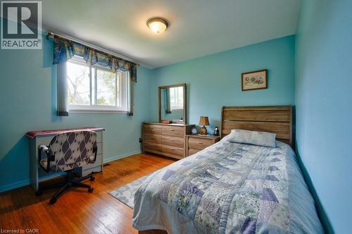 Bedroom featuring wood-finish flooring, a double-paned window, and a flush-mount ceiling light - 34 Westwood Crescent, Kitchener, ON - Indoor Photo Showing Bedroom